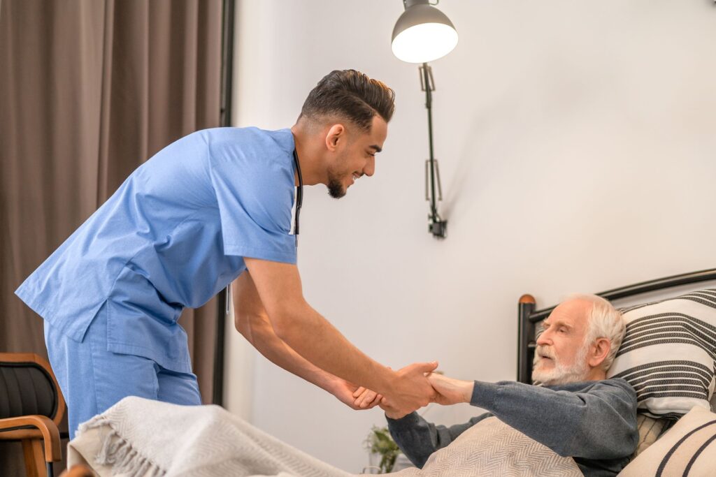 Krankenschwester mit bettlägerigem älteren Patienten